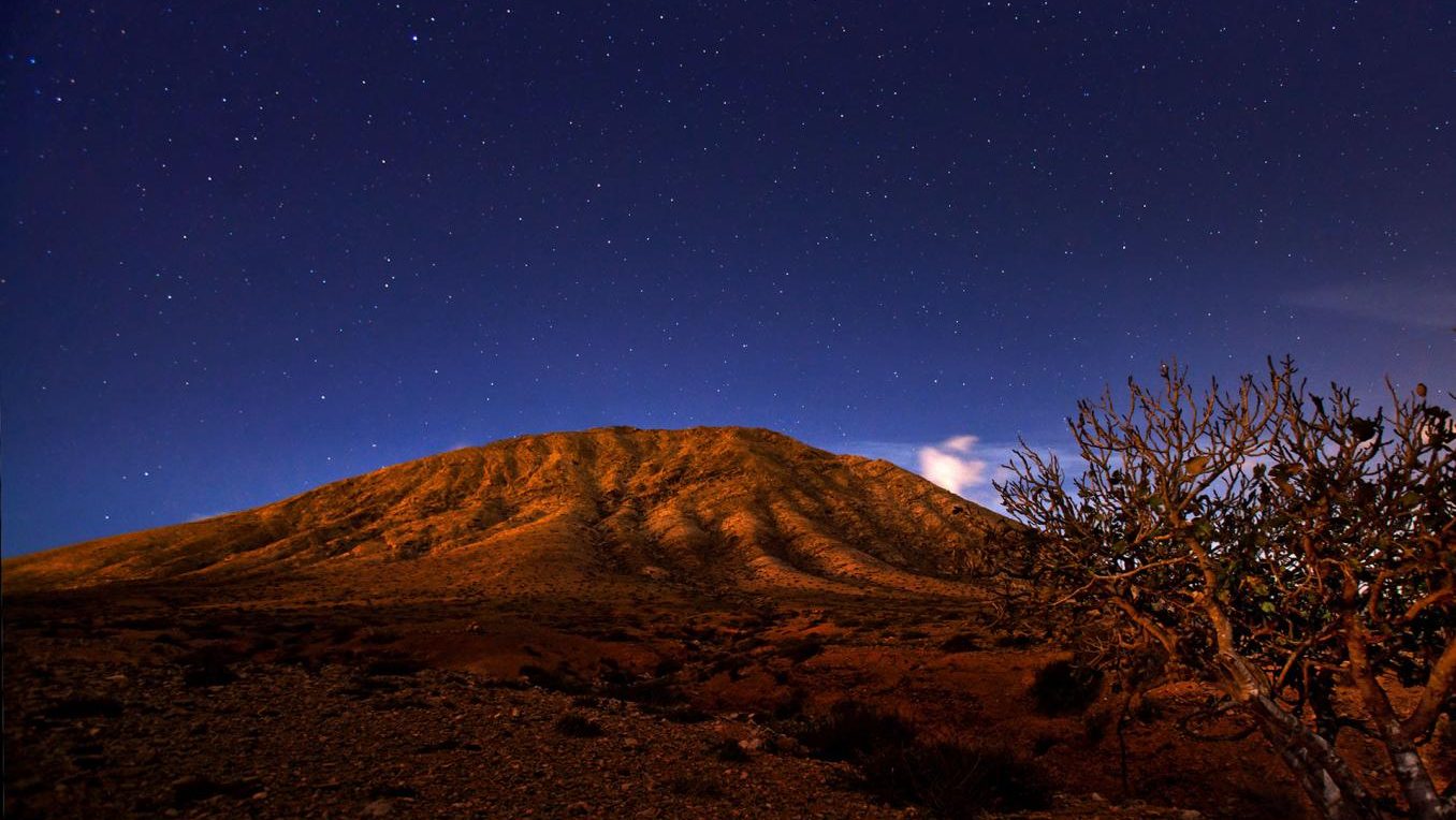 Una montaña y el cielo con estrellas