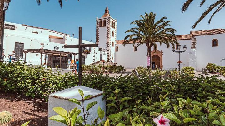 Una plaza con una iglesia de fondo