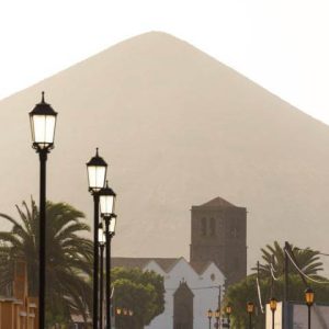 Foto de una iglesia con una montaña grnde de fondo